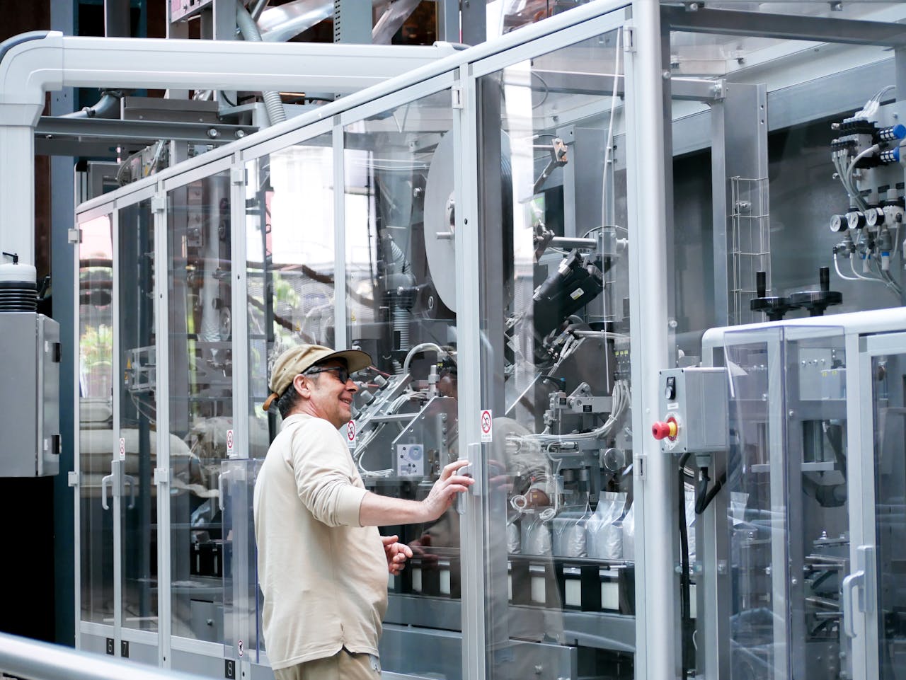 services-img Man observes and operates advanced industrial machinery behind glass indoors.